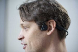 Hannes Sjöblad gillar hörlurarna som kringgår hörselnerven med hjälp av Cochlear-teknik och gör att du kan ta in ljud från olika enheter direkt via käkbenet. ”Då kan jag höra både vad som händer runt omkring och lyssna på musik eller prata i telefon samtidigt.” Foto: Anna Pella.