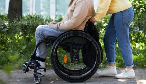 person i rullstol med assistent